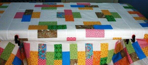 Quilt being basted on a table top 
