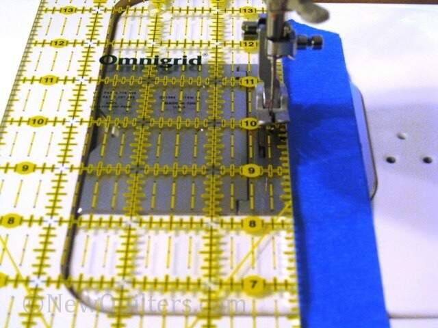 Photo of sewing machine presser foot with ruler and blue painter's tape seam guide