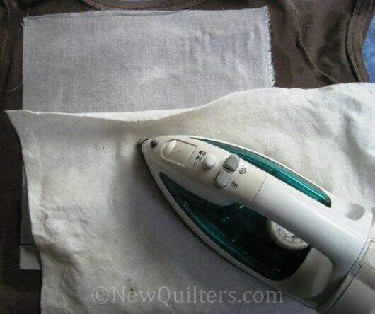 Photo of ironing interfacing to t-shirt with press cloth 