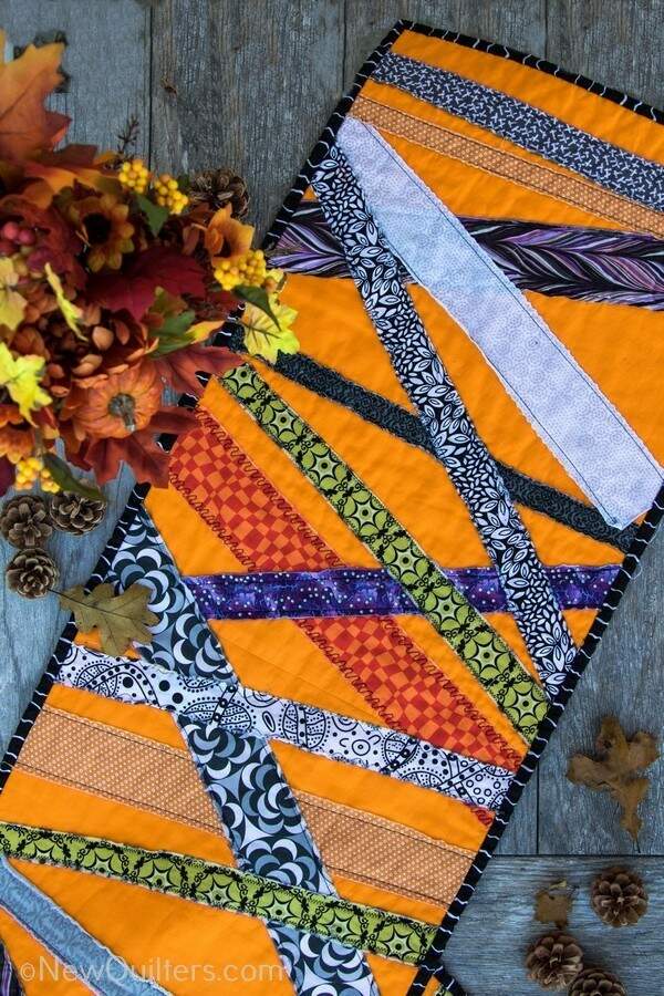 Get inspired to make a quick and easy Halloween table runner with this gallery of photos from the one we made. NewQuilters.com #halloweenquilt, #tablerunnerquilt, #tabletopperquilt