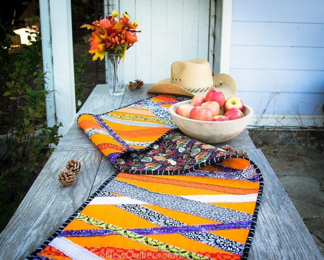 Get inspired to make a quick and easy Halloween table runner with this gallery of photos from the one we made. NewQuilters.com #halloweenquilt, #tablerunnerquilt, #tabletopperquilt