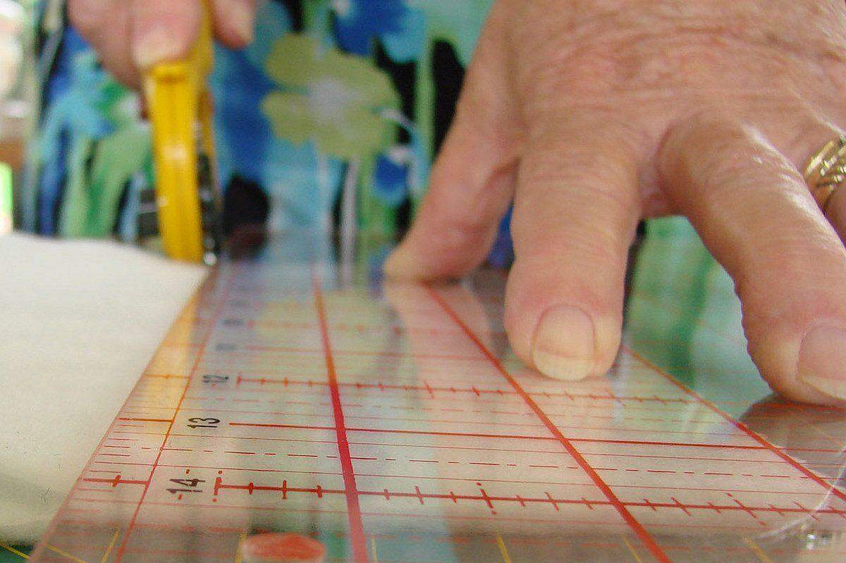 Quilting cutting with rotary cutter and ruler photo
